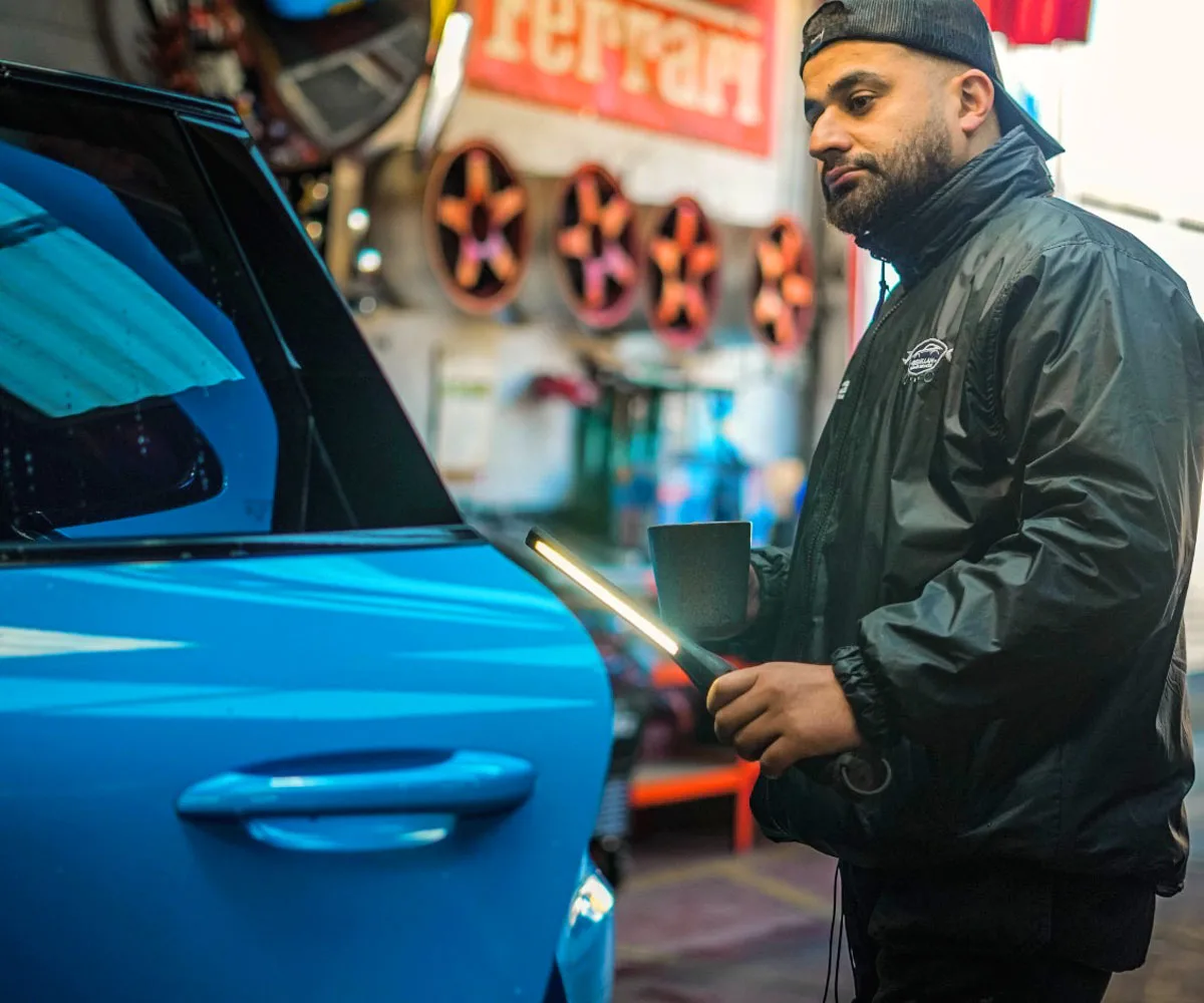 Technician working on a blue car in the Bismillah Garage Luton workshop